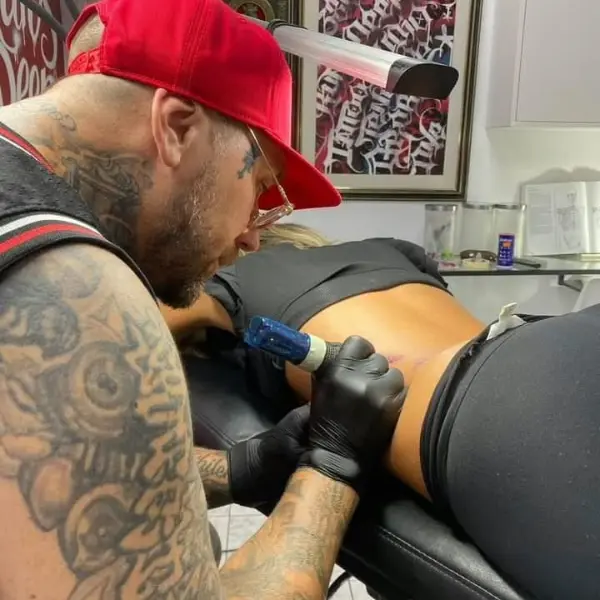 Artista de Mad Family tatuando